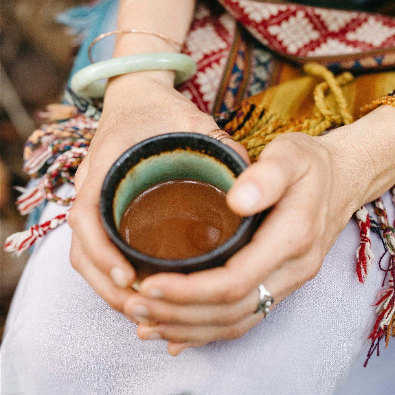 Featured photo: a warm mug of freshly whisked ceremonial cacao held in two hands
