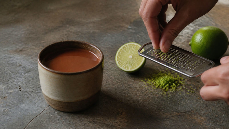Fresh lime zest being prepared beside ceremonial cacao